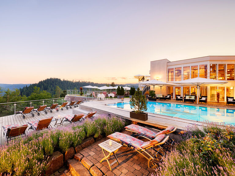 Das Gefühl mitten in der Natur zu sein, genießt man im Hotel Kronelamm im Schwarzwald aus nahezu jedem Winkel. Ein Außenpool mit Poolterrasse, sowie ein beleuchteter Teil des Wellnesshotels inmitten der grünen Natur des Schwarzwalds.