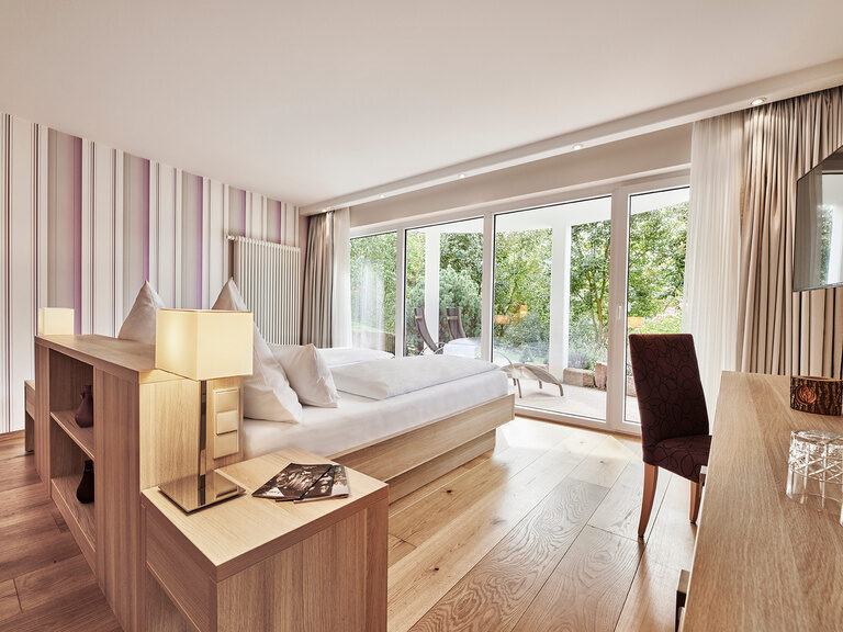 Die Juniorsuiten Waldnah liegen südwestlich zum Hand und verfügen über halbrunde Romantikbalkone oder Terrasse. Das Traumbett in der Juniorsuite Waldnah steht im hellen Zimmer direkt vor einem großen Panoramafenster.