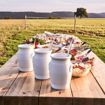 Auf einem großen Biertisch sind verschiedene Vorspeisen und Salatdressings als Buffet angerichtet.